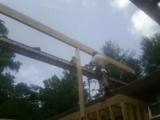 Carpenter setting a ridge beam over a new addition frame — Ice Dam Removal by Roofing Brothers in Combined Locks
