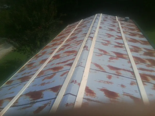 Rusted metal roof panels with new wood purlins before replacement — Storm Damage Roof Repair in Combined Locks by Roofing Brothers