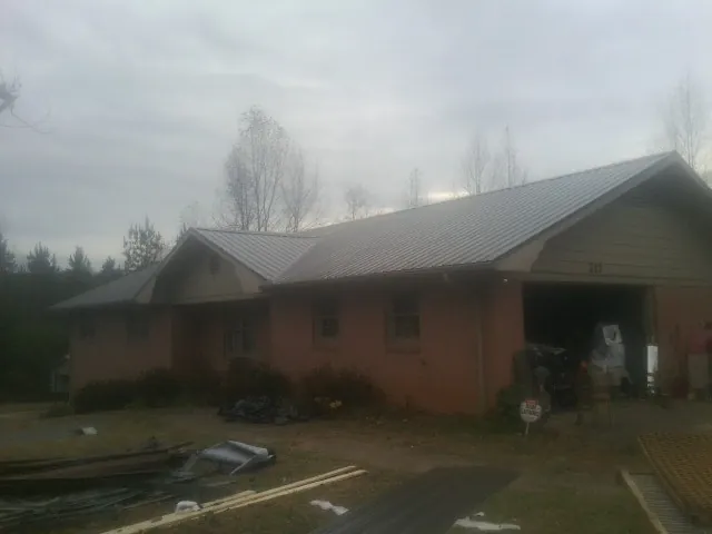 Gray metal roof on a stucco house with an attached garage in Combined Locks