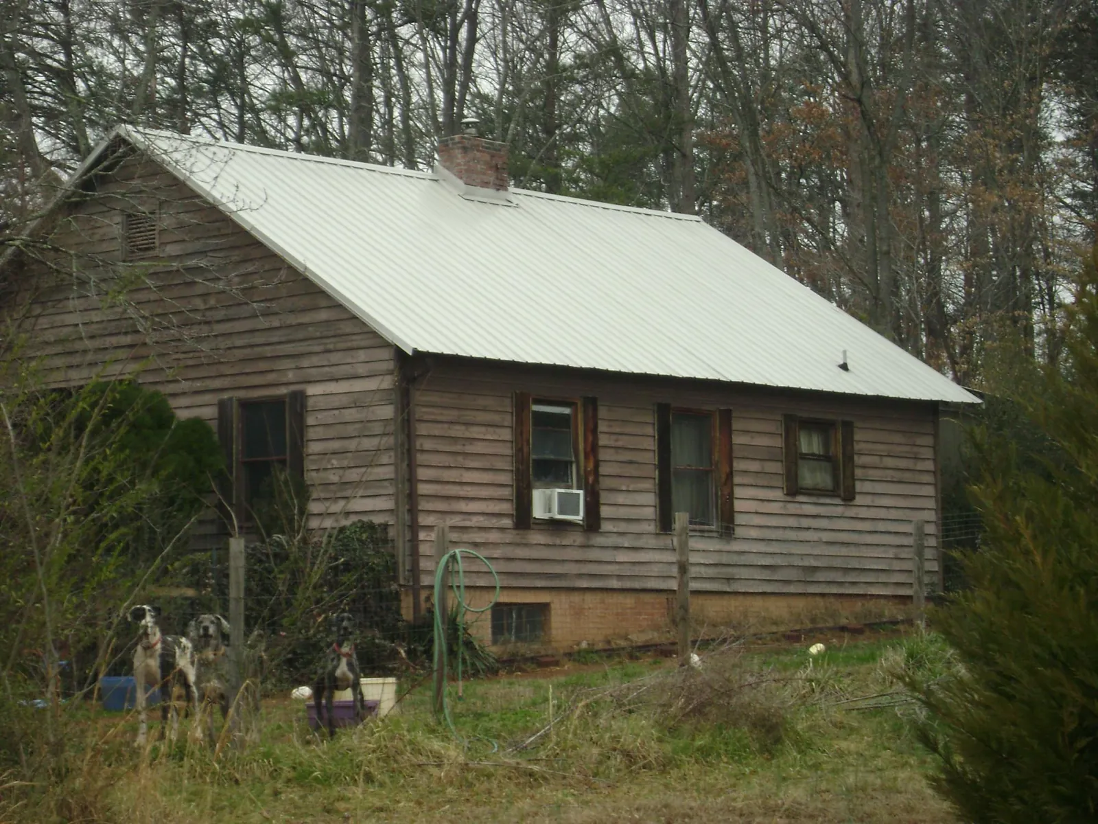 White metal roof on an old wood sided farmhouse, from a Metal Roof Installation job in Combined Locks
